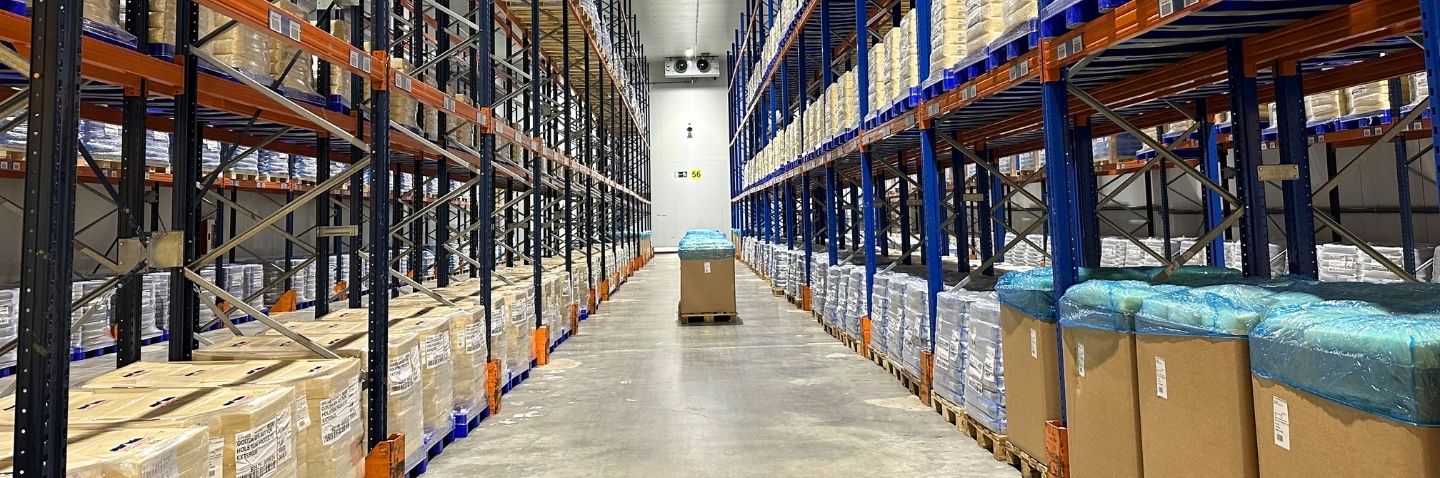 Almacén logístico con palés en estanterías industriales para operativas de temperatura controlada en logística alimentaria